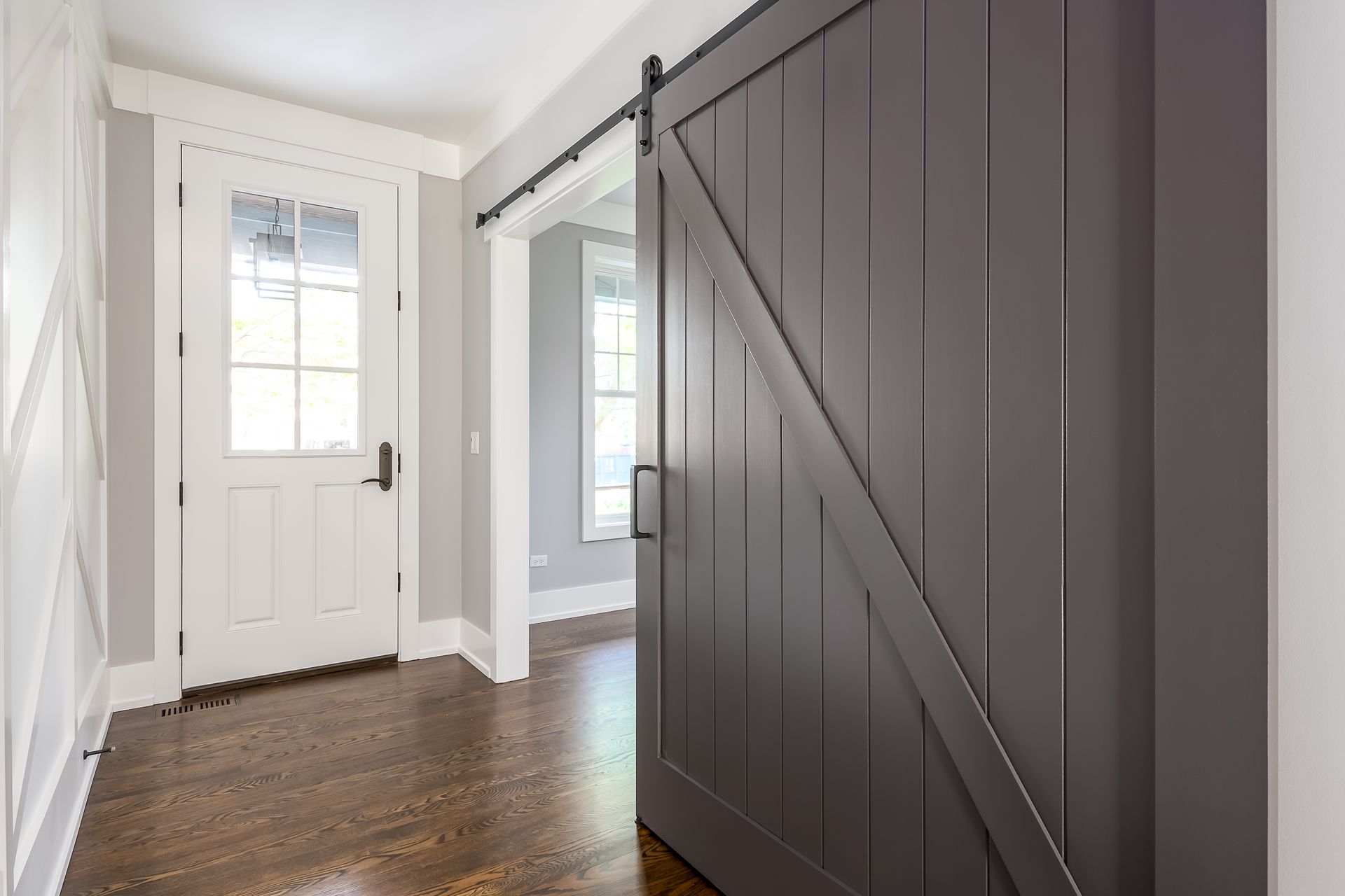 Hallway with gray barn door and white door.