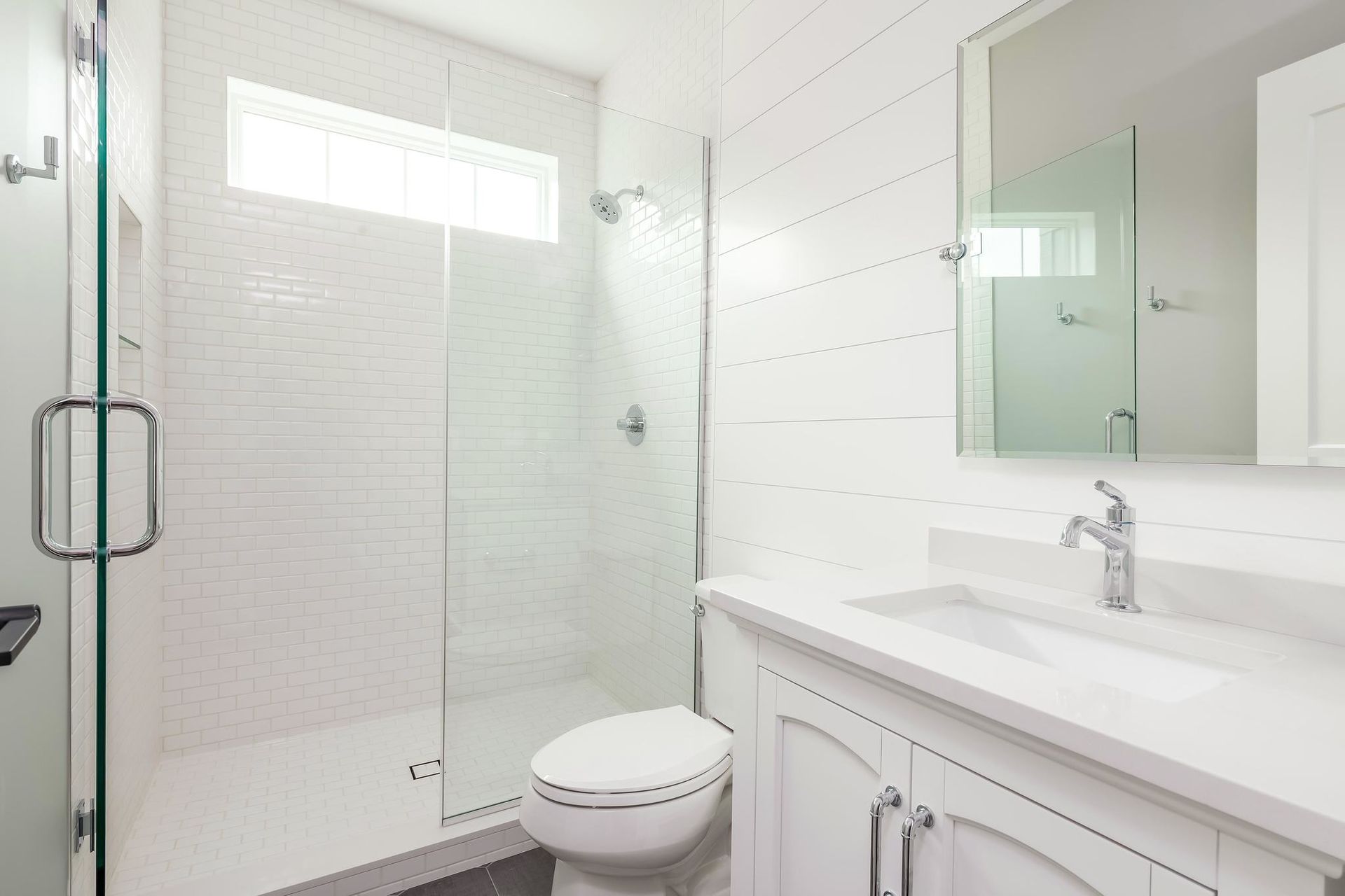 White bathroom with shower, vanity, and toilet.  Clean, modern design.
