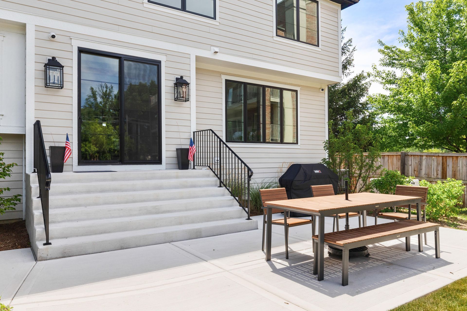 Back patio with concrete steps, sliding glass door, and a dining table.