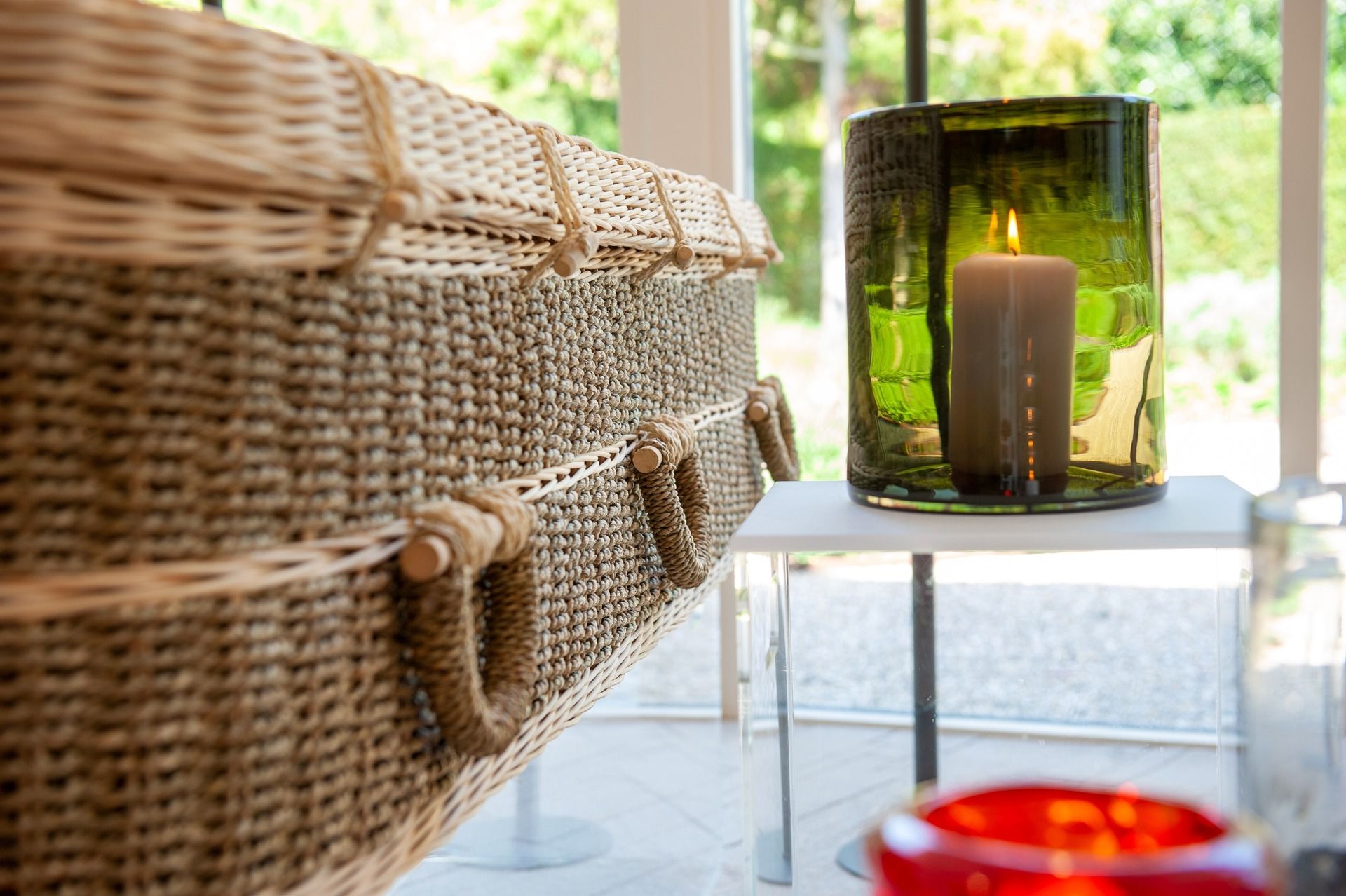 A wicker coffin is sitting on a table next to a candle.