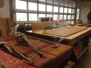 A wooden table with a snake on it in a workshop.