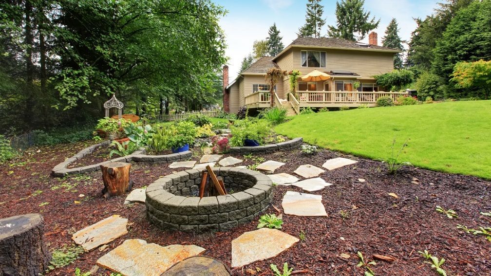 There is a fire pit in the backyard of a house.