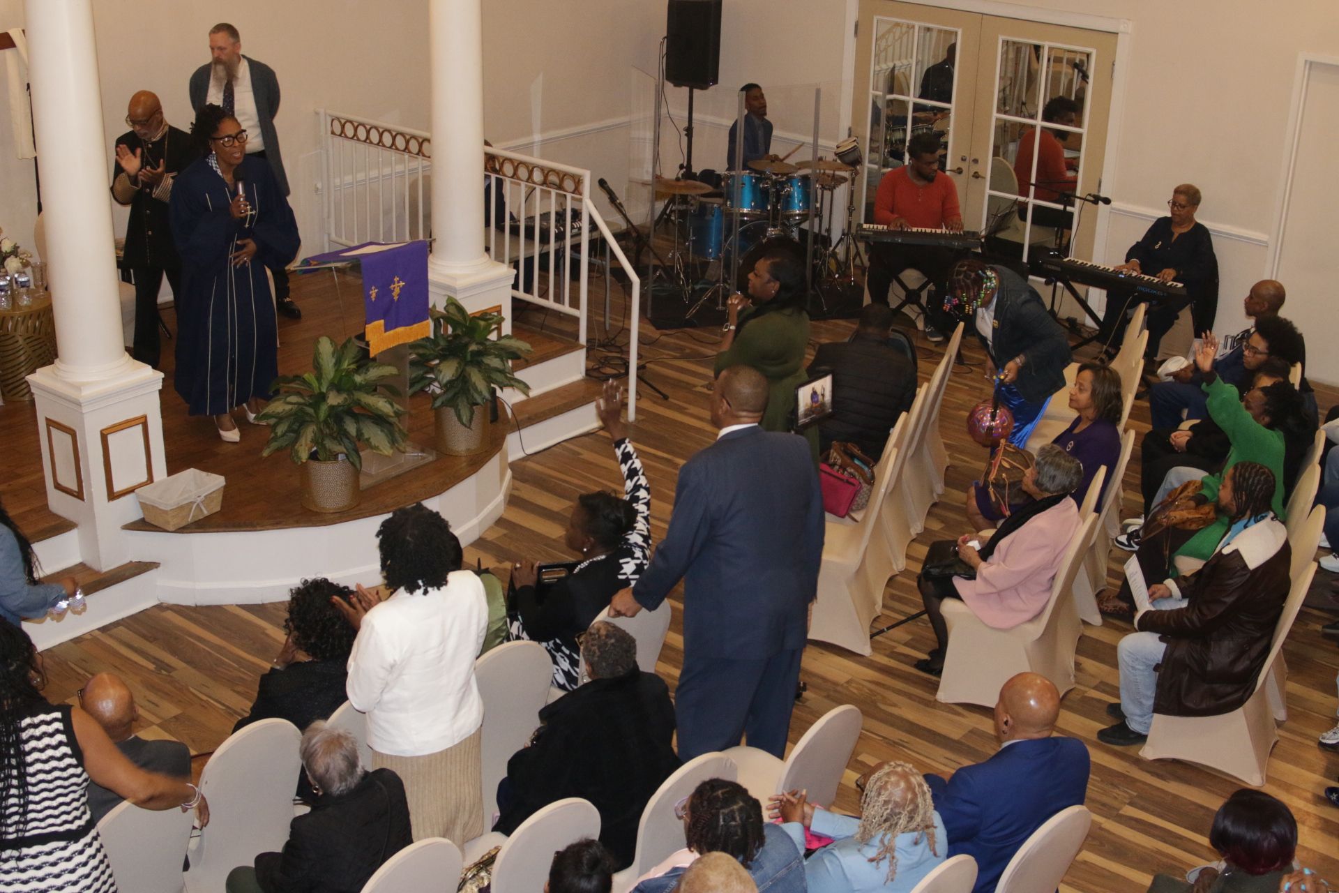 People gathered in a church sanctuary listening to speakers near the altar.