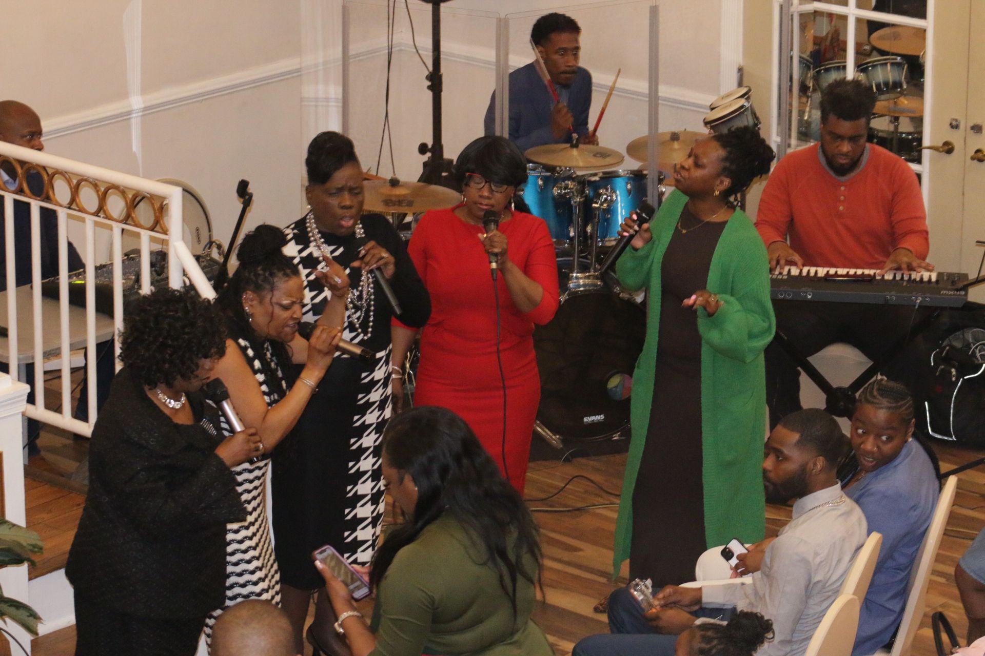 Church choir singing and performing with microphones and drums inside a worship hall