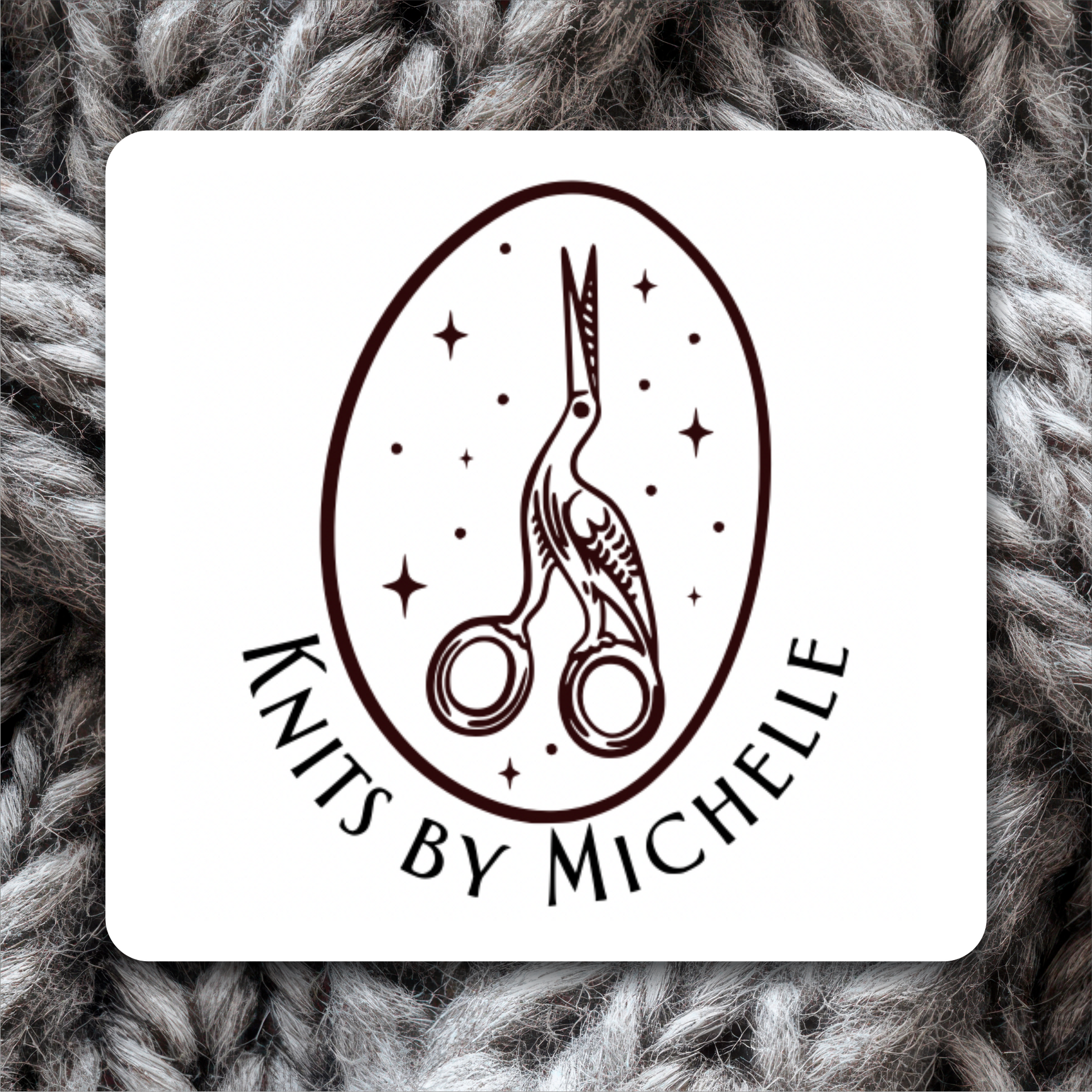 Bird shape designed scissors inside an oval and text reading “Knits by Michelle” on a white square against gray knit yarn.
