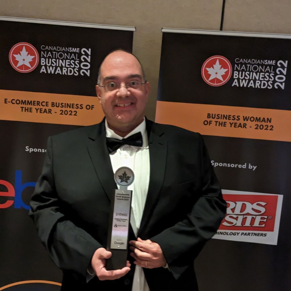 A man in a suit is holding a canadian business award