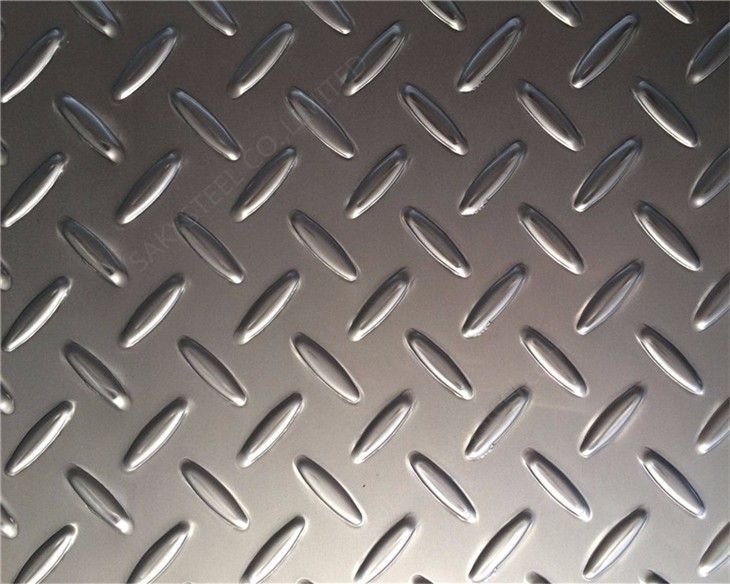 Diamond plate metal surface, shiny, with raised, repeating diamond pattern.
