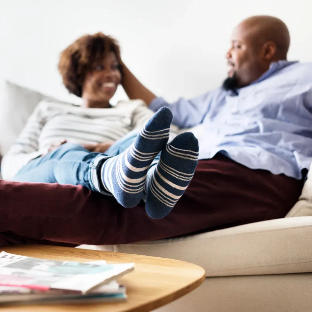 A woman sitting happily on a couch.