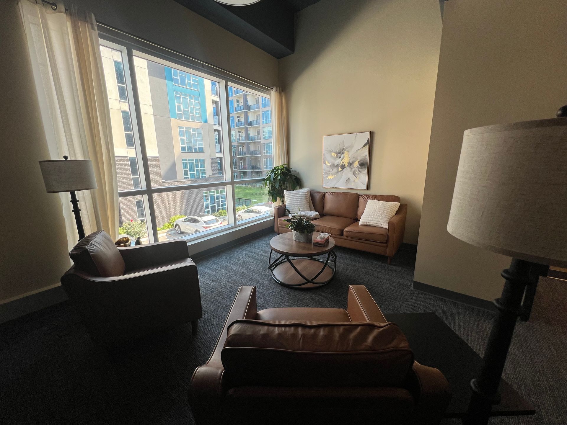 Counselor speaking with a client in a bright, modern office with plants and framed wall art