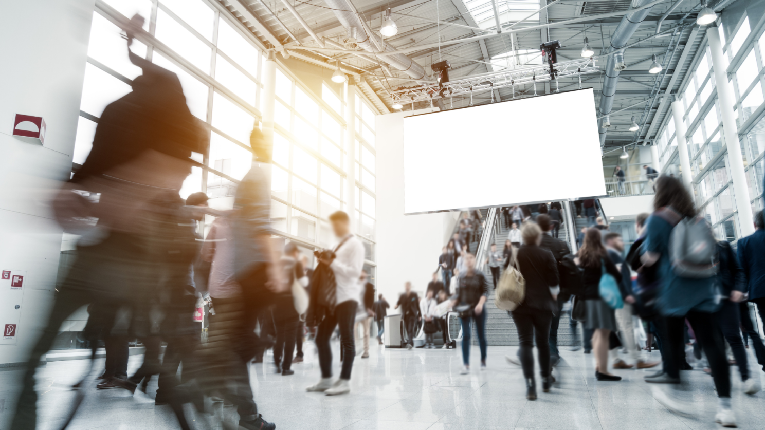 A blurry picture of a crowd of people walking in a building.
