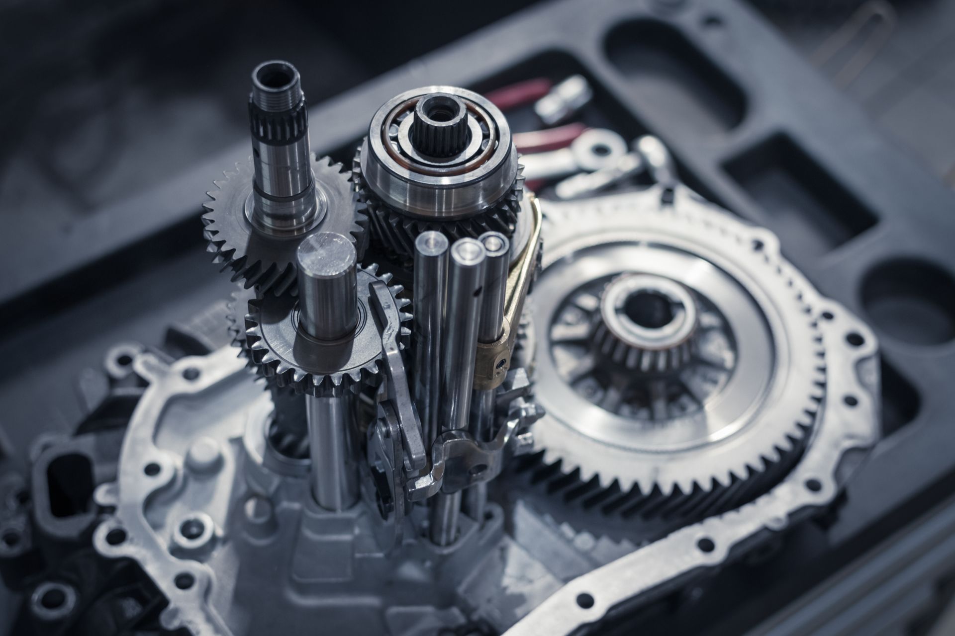 Close-up of shiny metal gears and shafts inside a mechanical gearbox assembly.
