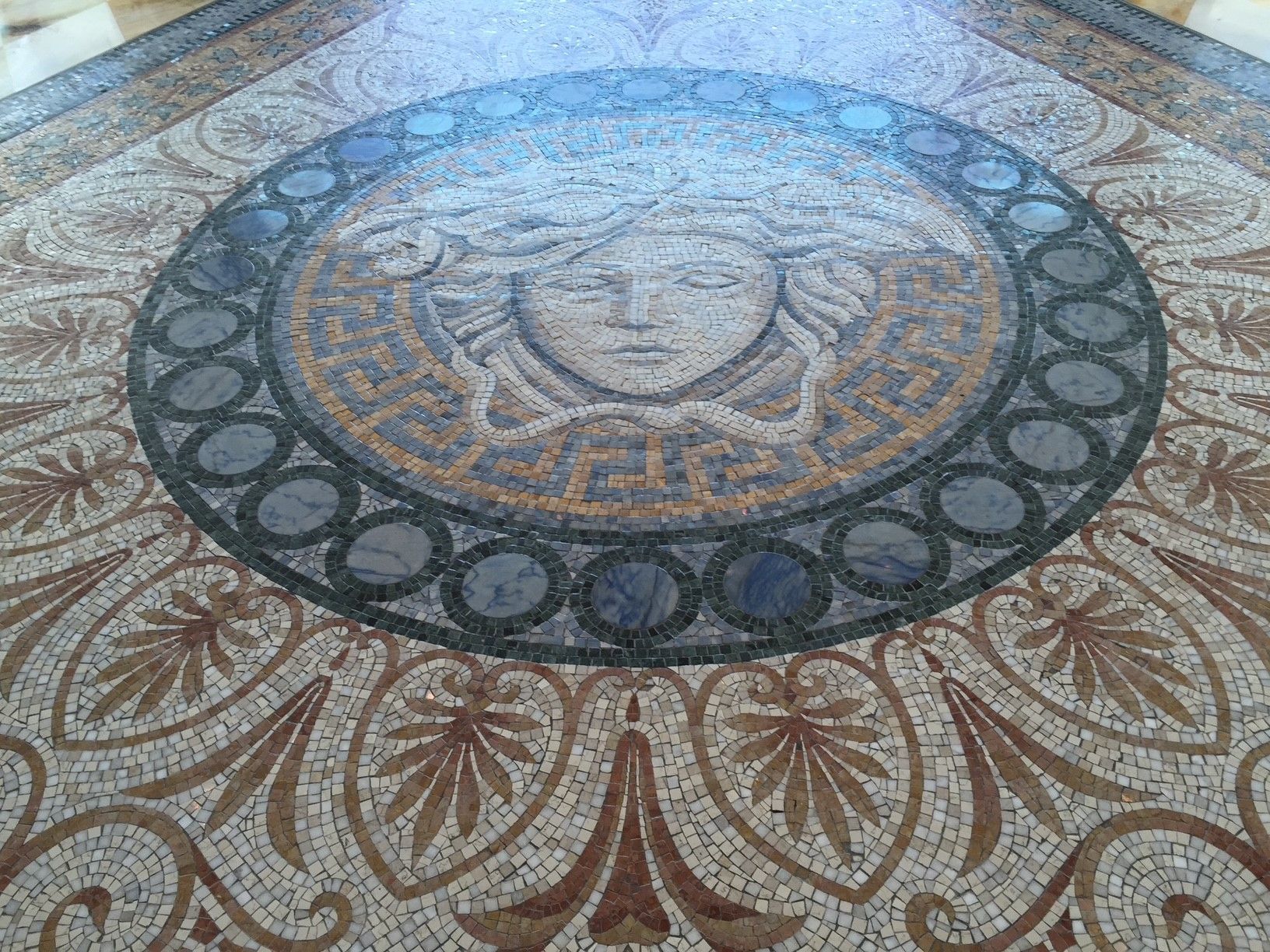 A mosaic floor with a medusa head in the center.