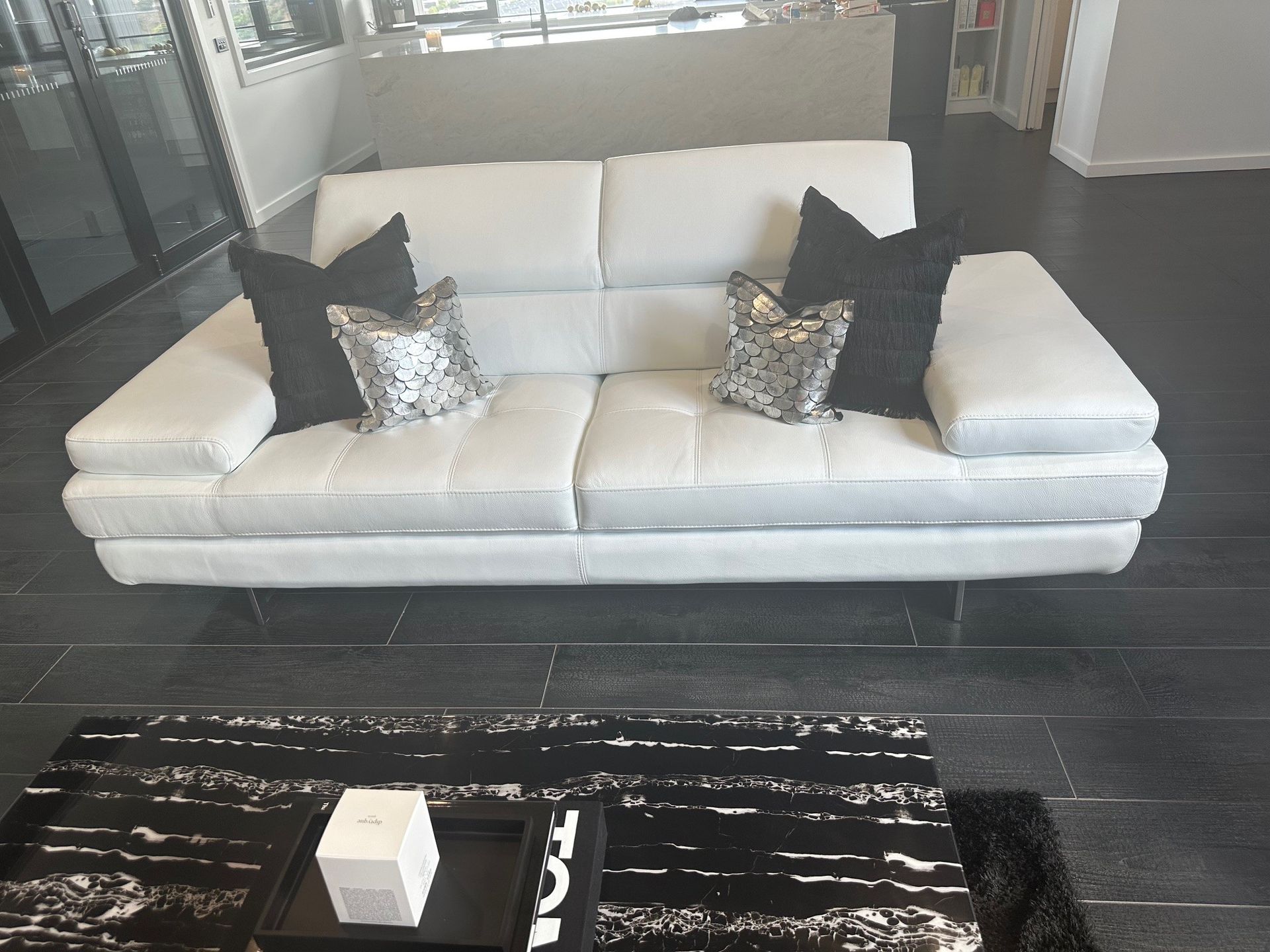 A white couch with black pillows sits in a living room