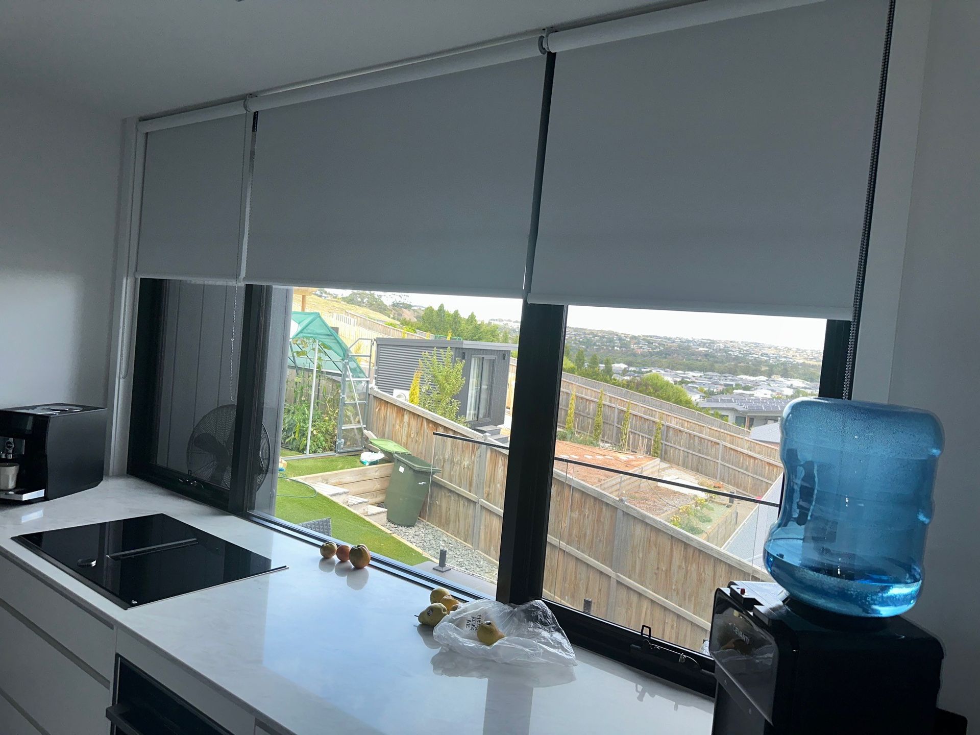 A kitchen with a large window and a water bottle next to the counter.