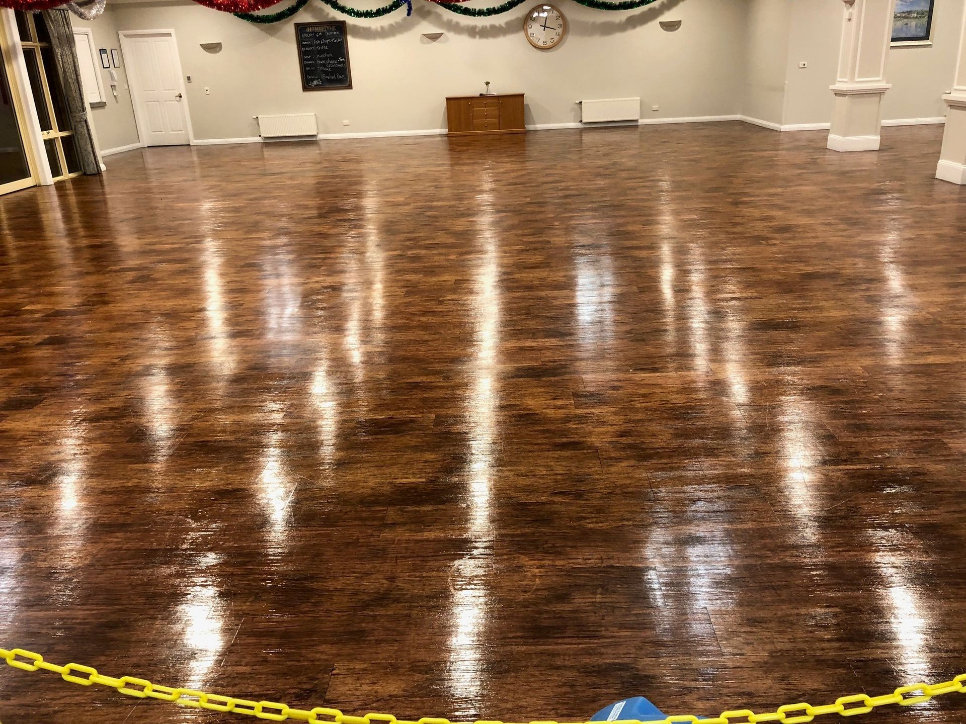 A large room with a wooden floor and a yellow chain around it