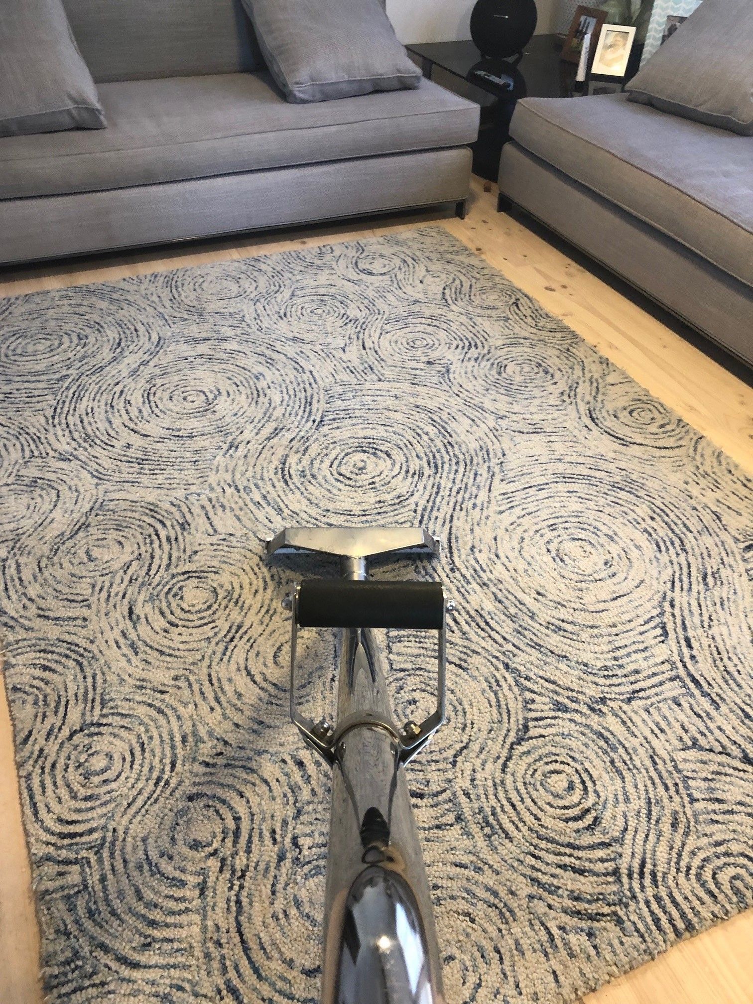 A carpet cleaner is cleaning a rug in a living room.