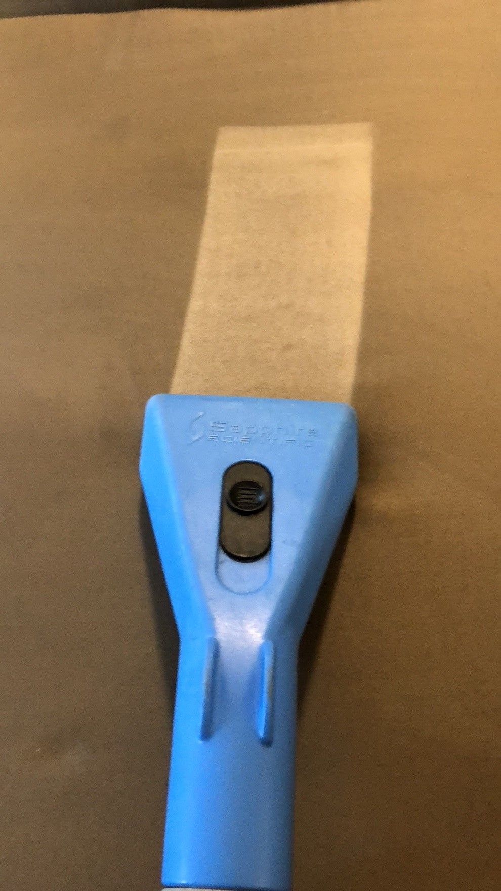 A blue upholstery cleaner is being used to clean a couch.