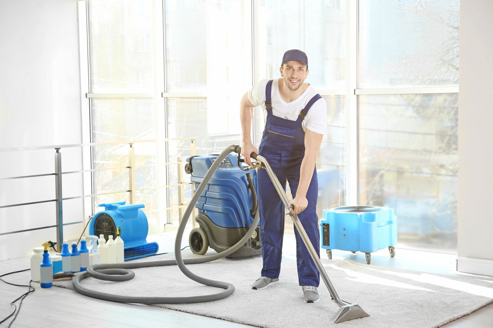 A carpet cleaning employee removing dirt from a carpet in an office. A carpet cleaning employee removing dirt from a carpet in an office.