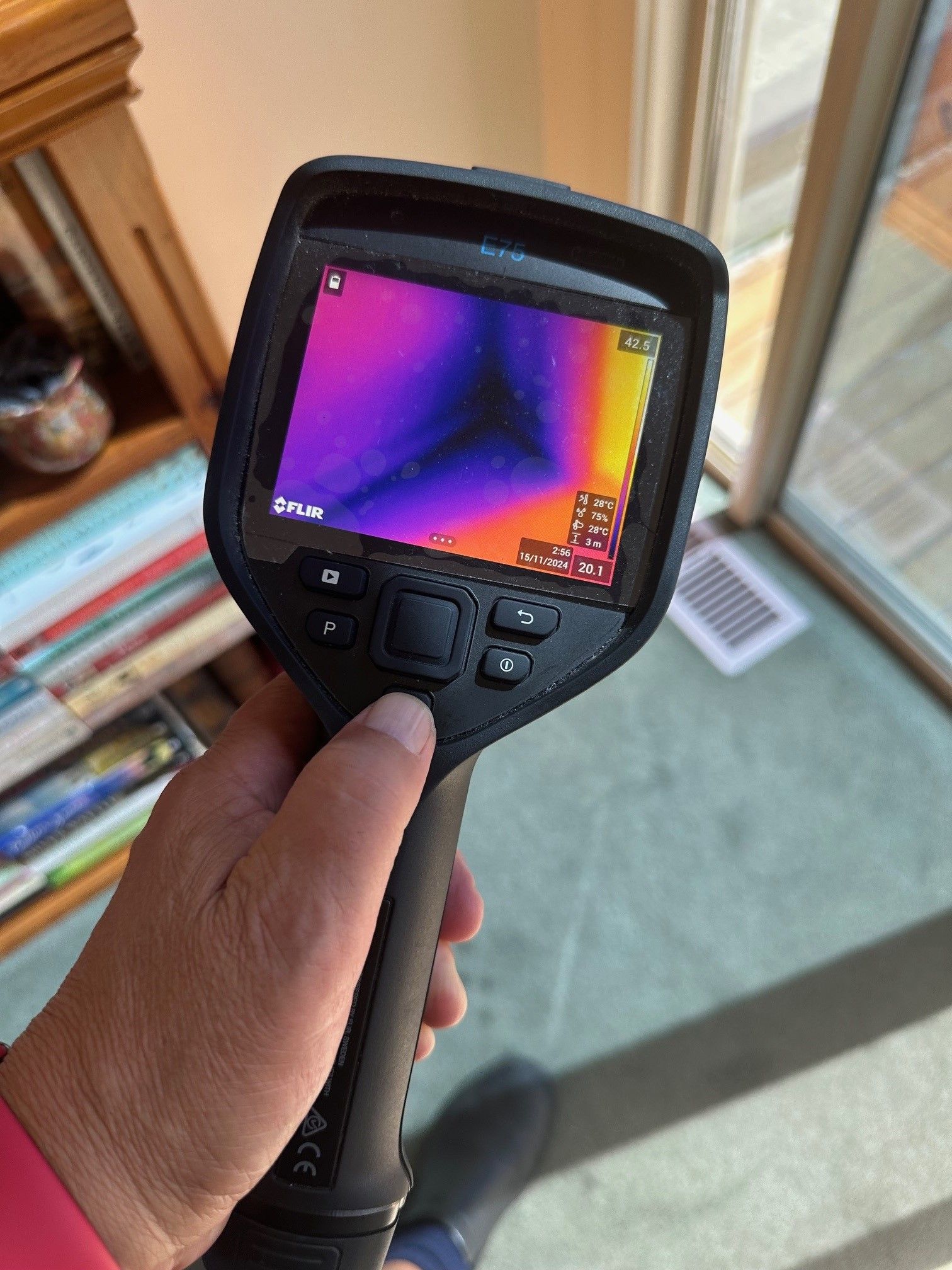 A person is holding a thermal camera in their hand.