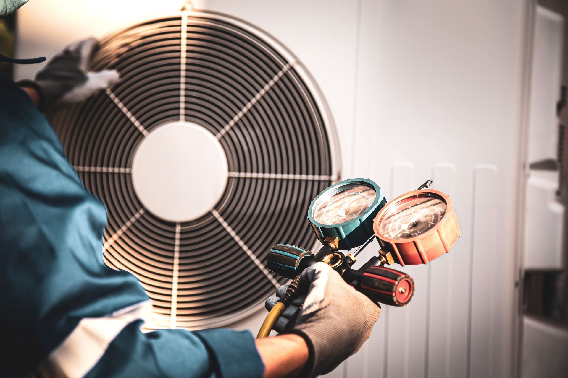 HVAC technician inspecting an air conditioner with gauges.