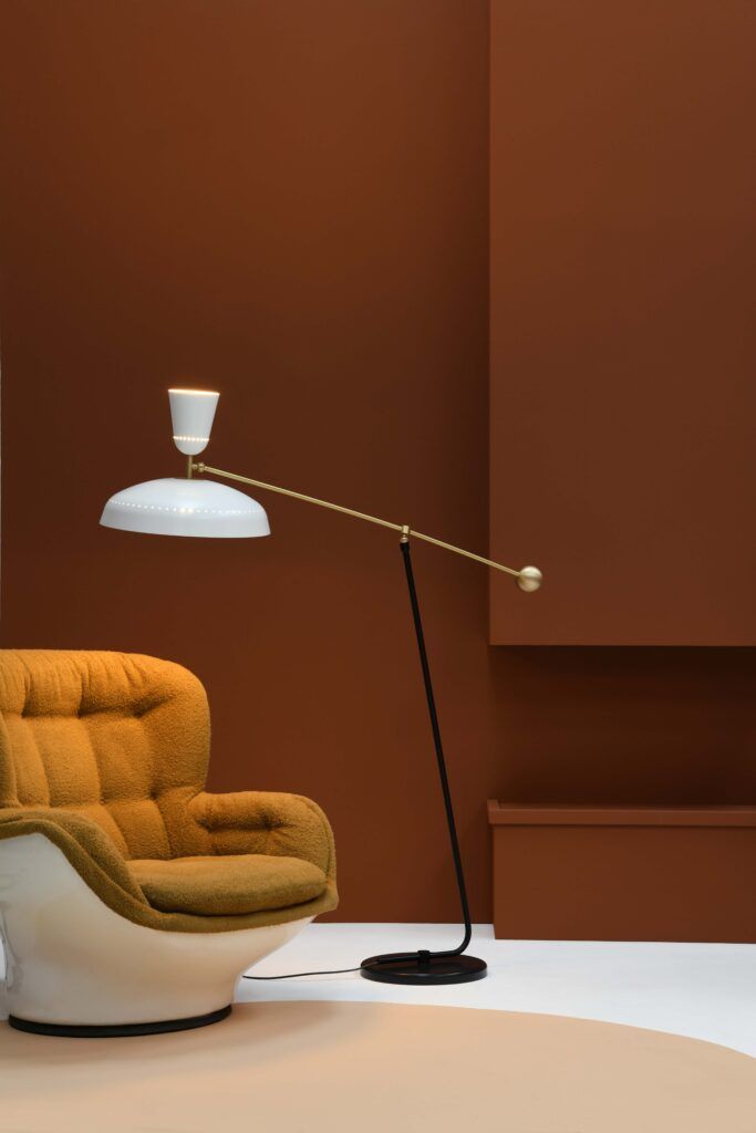 Rom i mid-century-moderne stil med brune vegger, stol og gulvlampe med hvit skjerm.