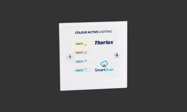 Hvitt, firkantet kontrollpanel med teksten «COLOUR ACTIVE LIGHTING», «Thorlux» og «SmartScan», med fire lysnivåknapper og pluss/minus-knapper.