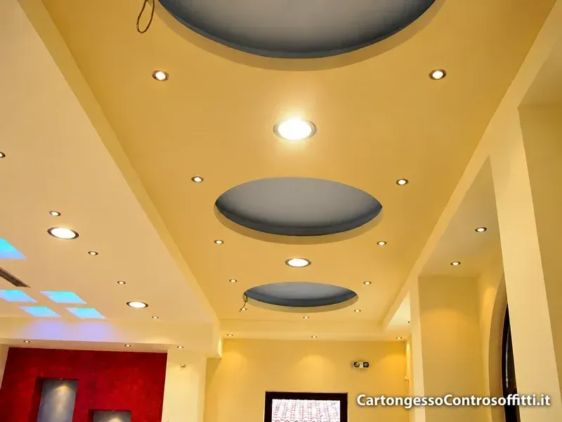 Controsoffitto in cartongesso con rientranze circolari e faretti incassati.