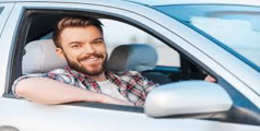 A man with a beard is sitting in a car and smiling. A man with a beard is sitting in a car and smiling.