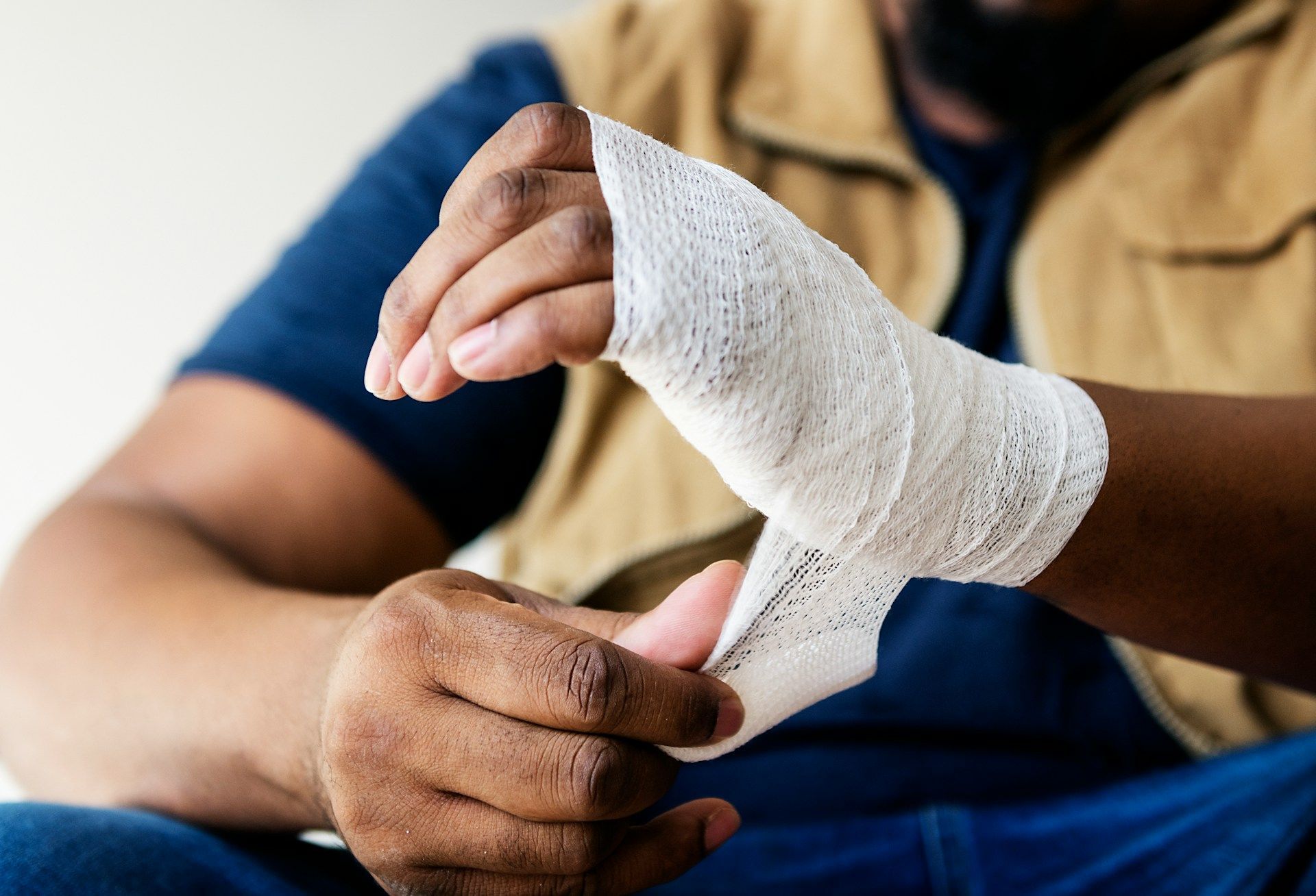 A person wrapping an elastic medical bandage around their wrist to provide support.