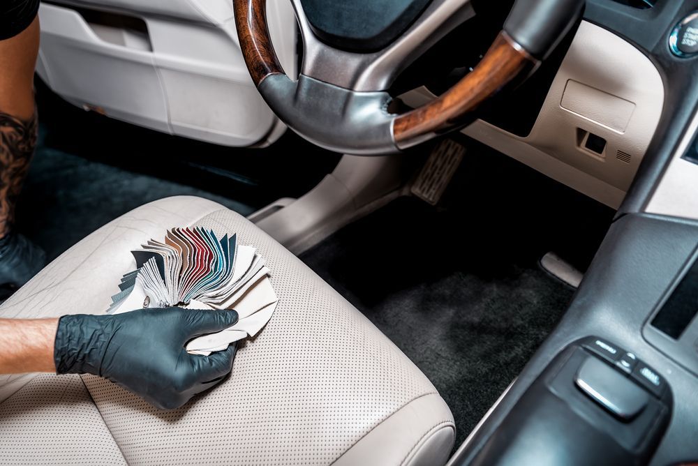 A Person Wearing Black Gloves Is Holding A Stack Of Samples In A Car — Townsville Car Care Centre In Aitkenvale, QLD