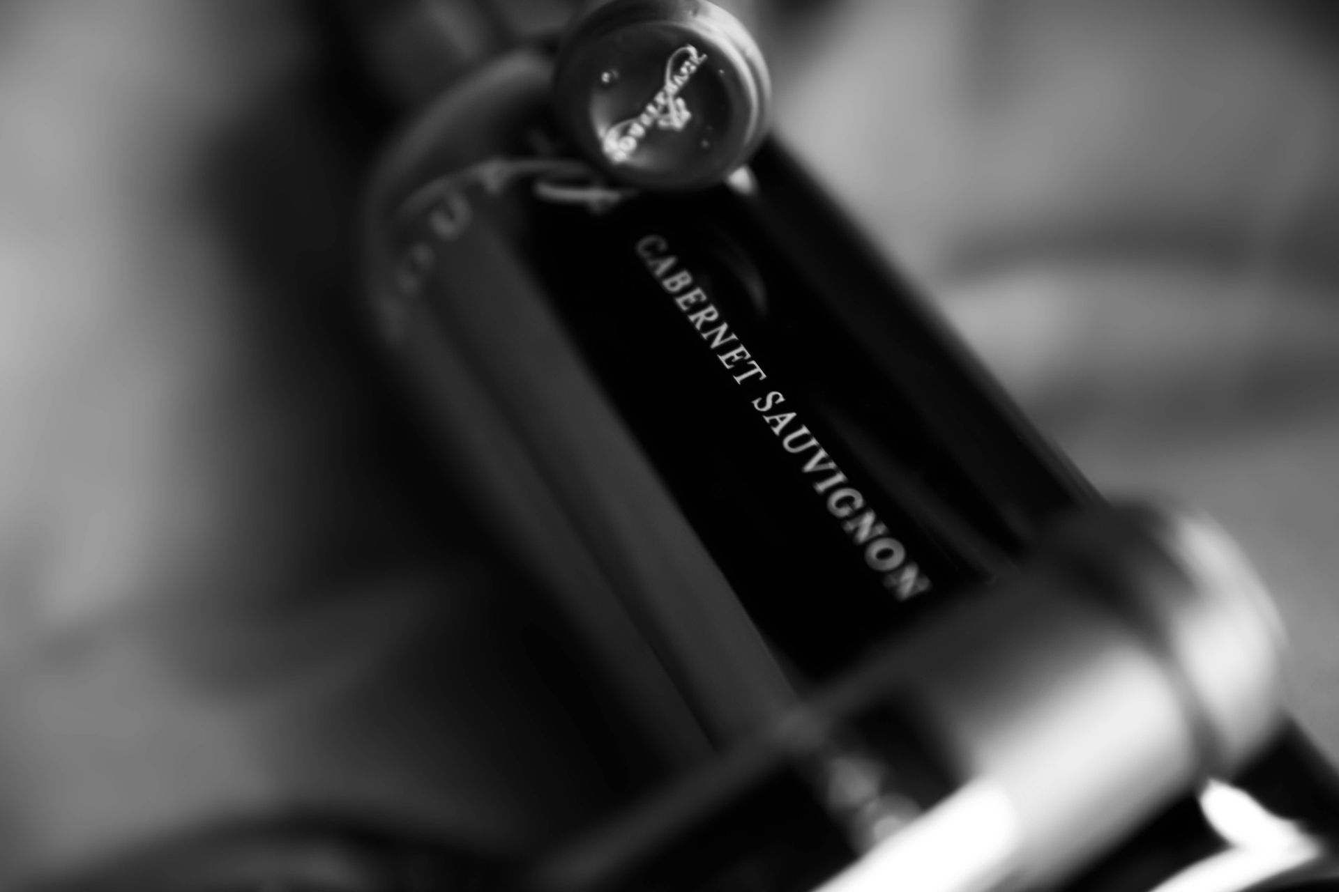 Close-up of a black Clarins skincare tube with a silver cap on a soft gray background