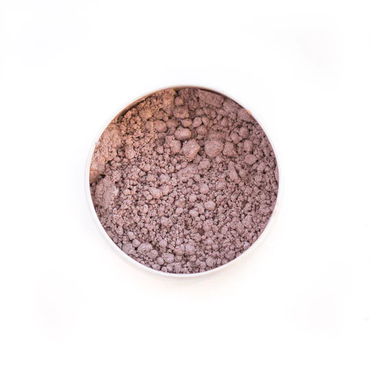 A white bowl filled with purple powder on a white background.