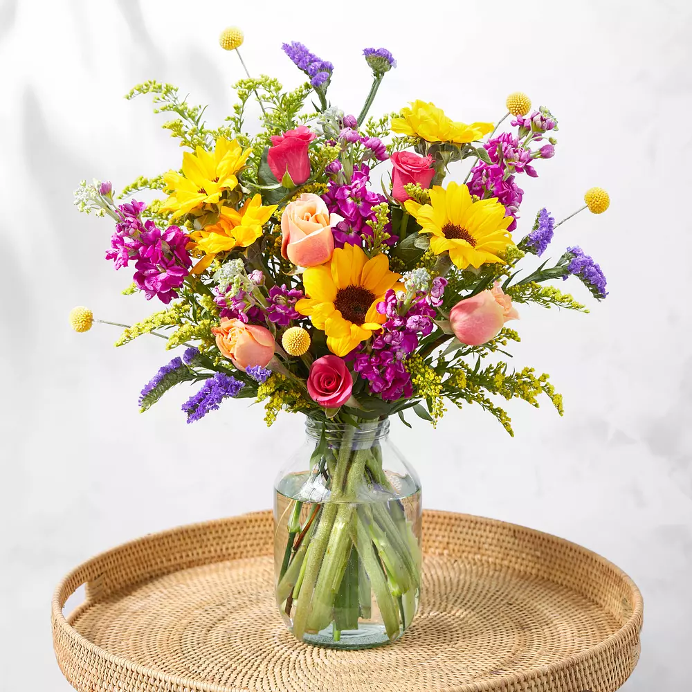 A vase filled with colorful flowers is sitting on a table.