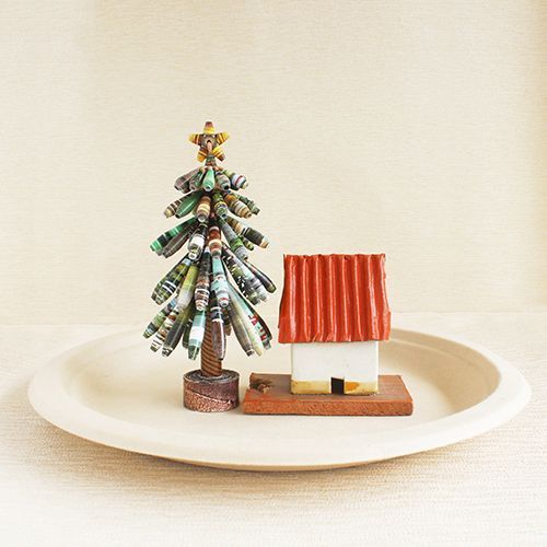 A white plate with a christmas tree and a small house on it