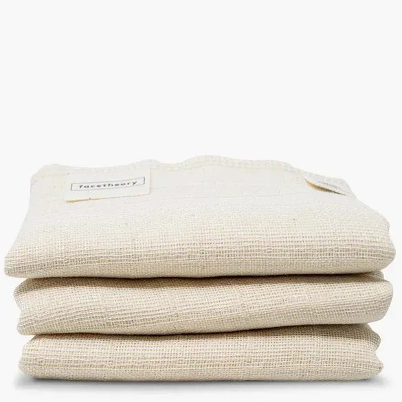 Three white towels are stacked on top of each other on a white background.