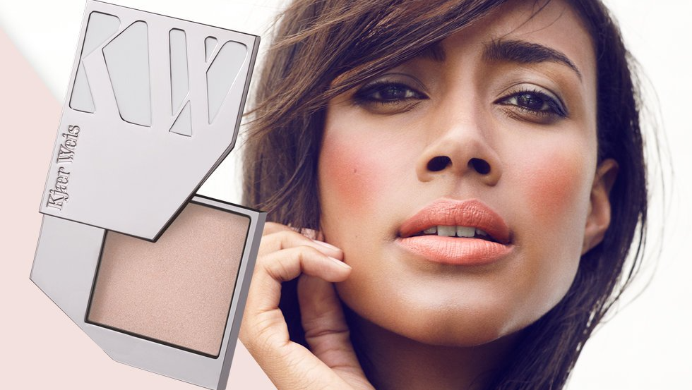A close up of a woman 's face with a box of Kjaer Weis makeup in the background.