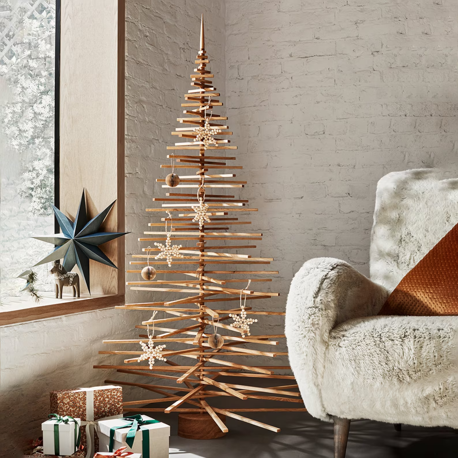 A wooden christmas tree is sitting in a living room next to a couch.