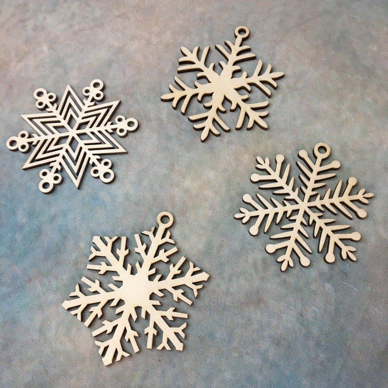 Four wooden snowflakes are sitting on a blue surface