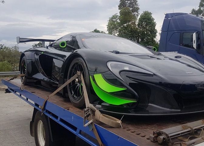 A Tow Truck With a Red Car on the Back — Mick’s Towing Service Pty Ltd in Carrara, QLD