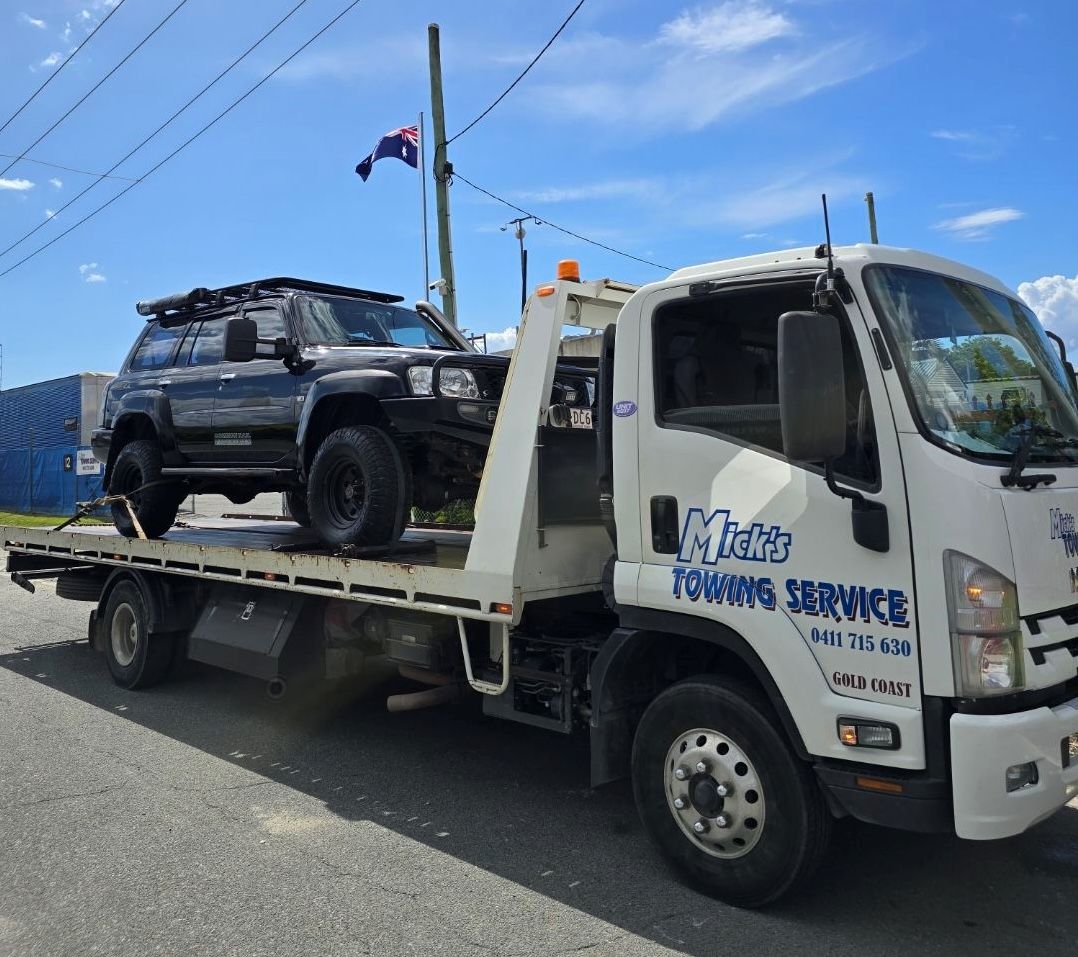 Black SUV Loaded on a White Tow Truck — Mick's Towing Service Pty Ltd in Carrara, QLD