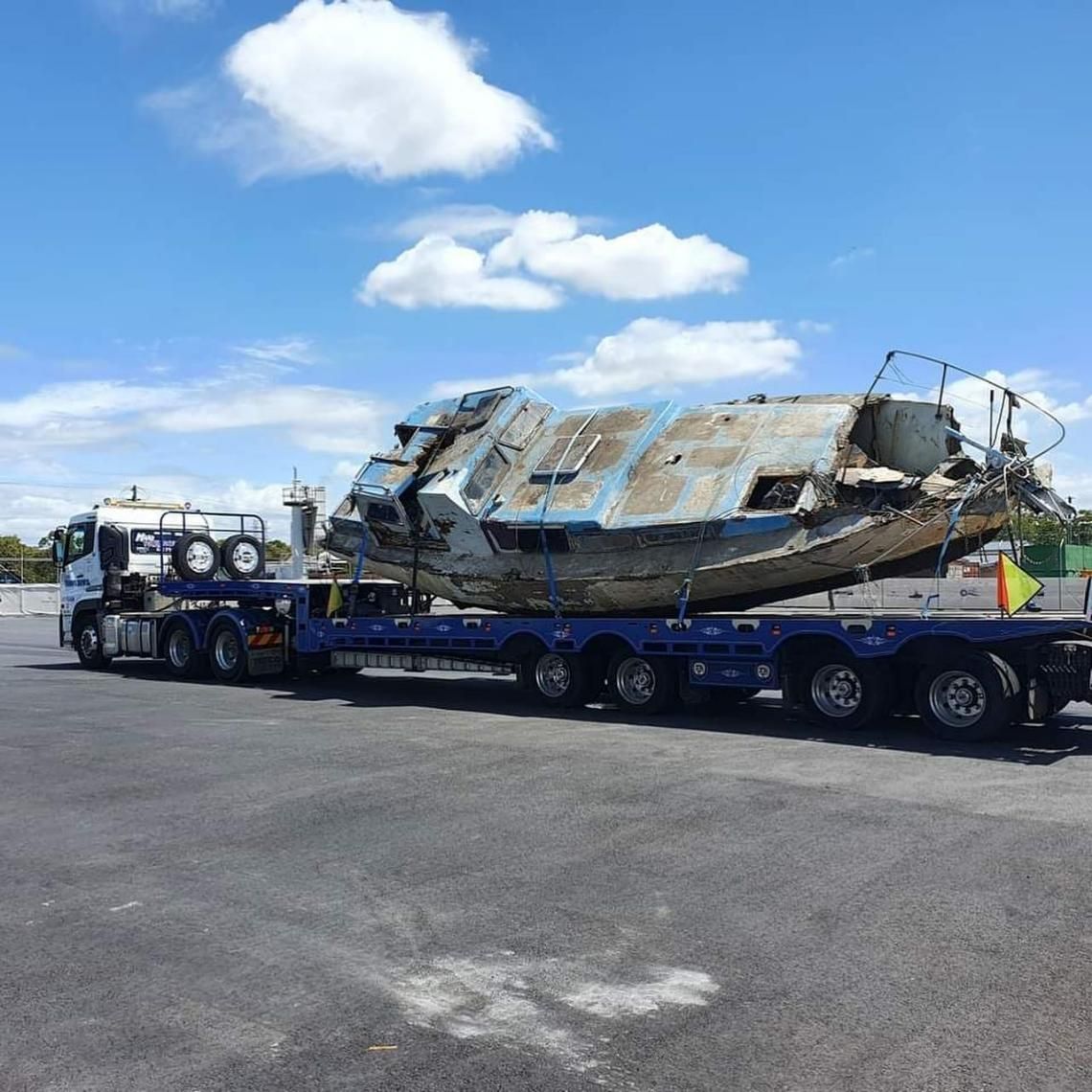 A Boat Is Being Transported on A Trailer in A Parking Lot — Mick's Towing Service Pty Ltd in Carrara, QLD