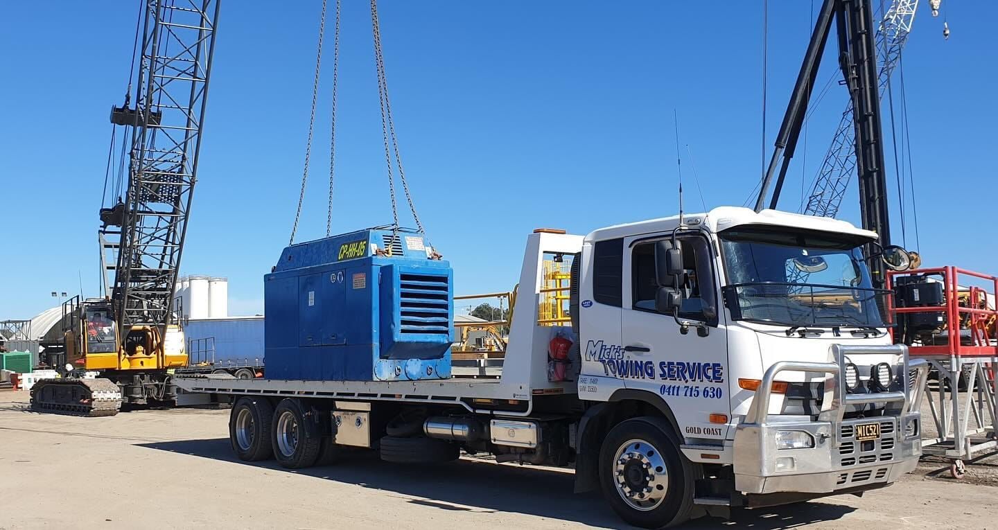 A White Truck With a Blue Box on the Back is Parked in a Parking Lot — Mick's Towing Service Pty Ltd in Carrara, QLD
