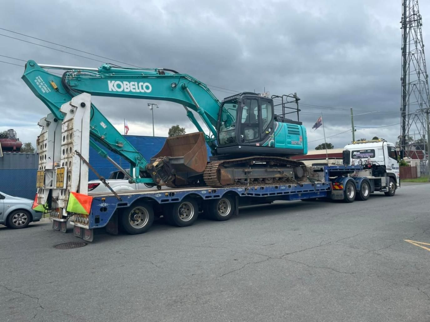 A Large Excavator is Being Transported on a Trailer — Mick's Towing Service Pty Ltd in Carrara, QLD