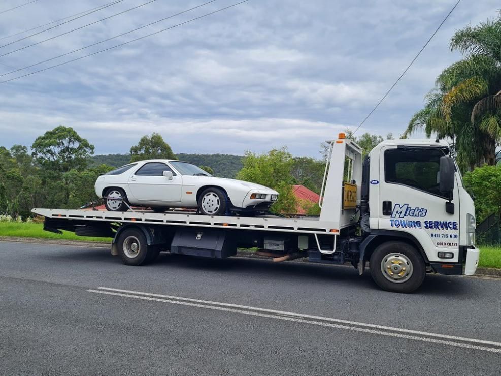 A White Car Is on The Back of A Tow Truck — Mick's Towing Service Pty Ltd in Carrara, QLD