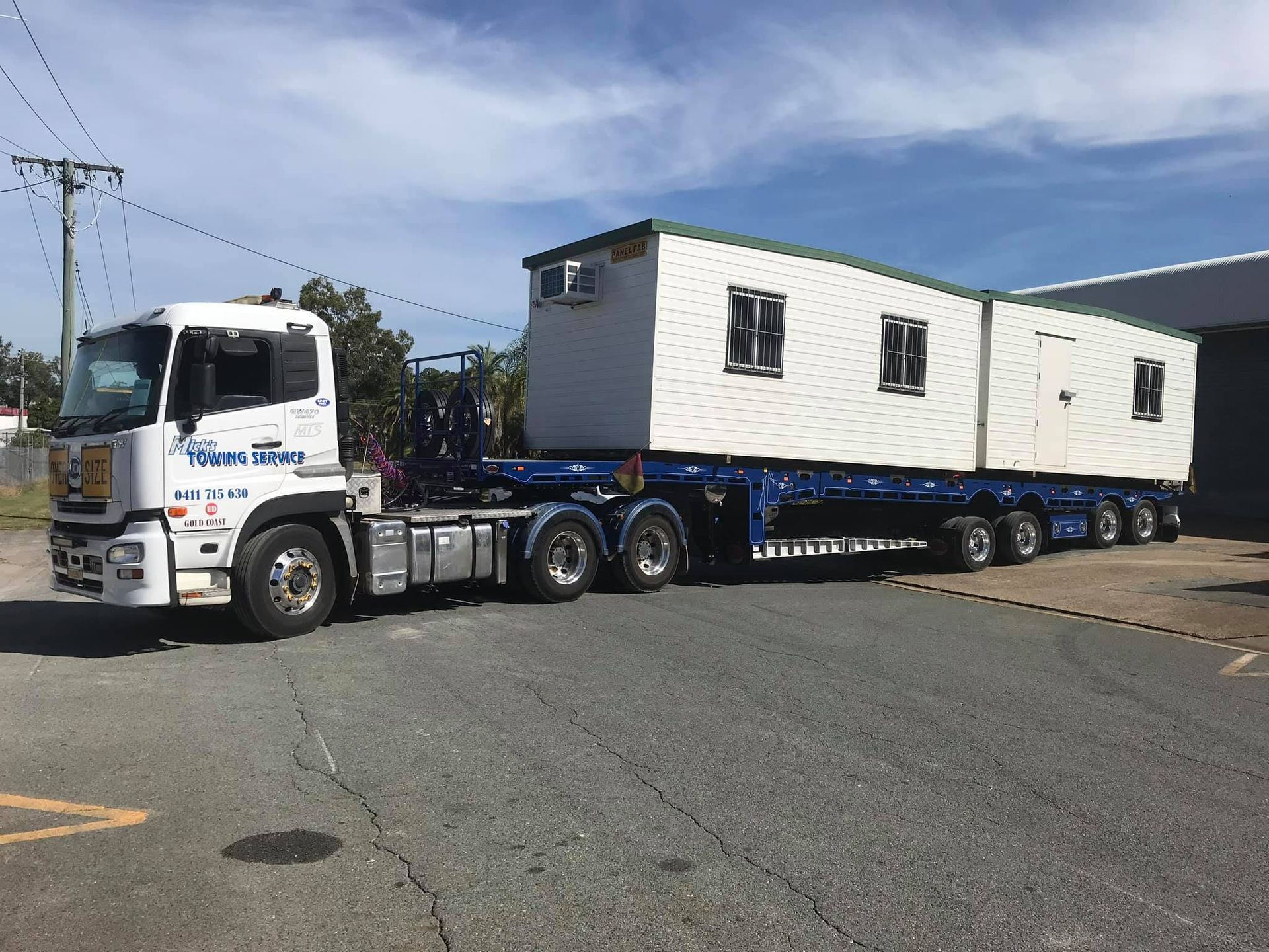 A semi truck is carrying a trailer with a container on it.