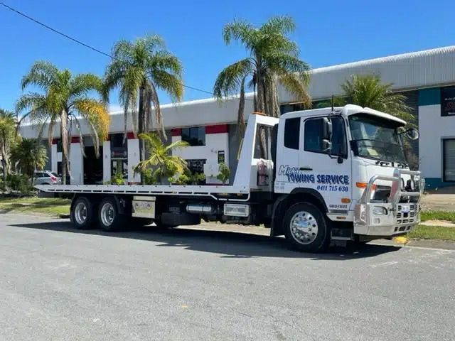 A Towing Service Truck is Parked in Front of a Building — Mick's Towing Service Pty Ltd in Carrara, QLD