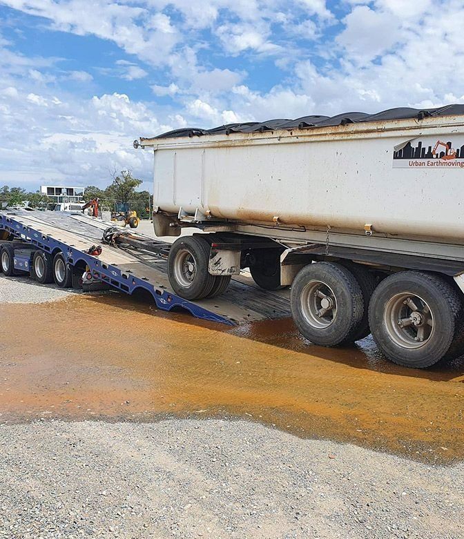 A Dump Truck is Being Towed by a Flatbed Trailer — Mick's Towing Service Pty Ltd in Carrara, QLD