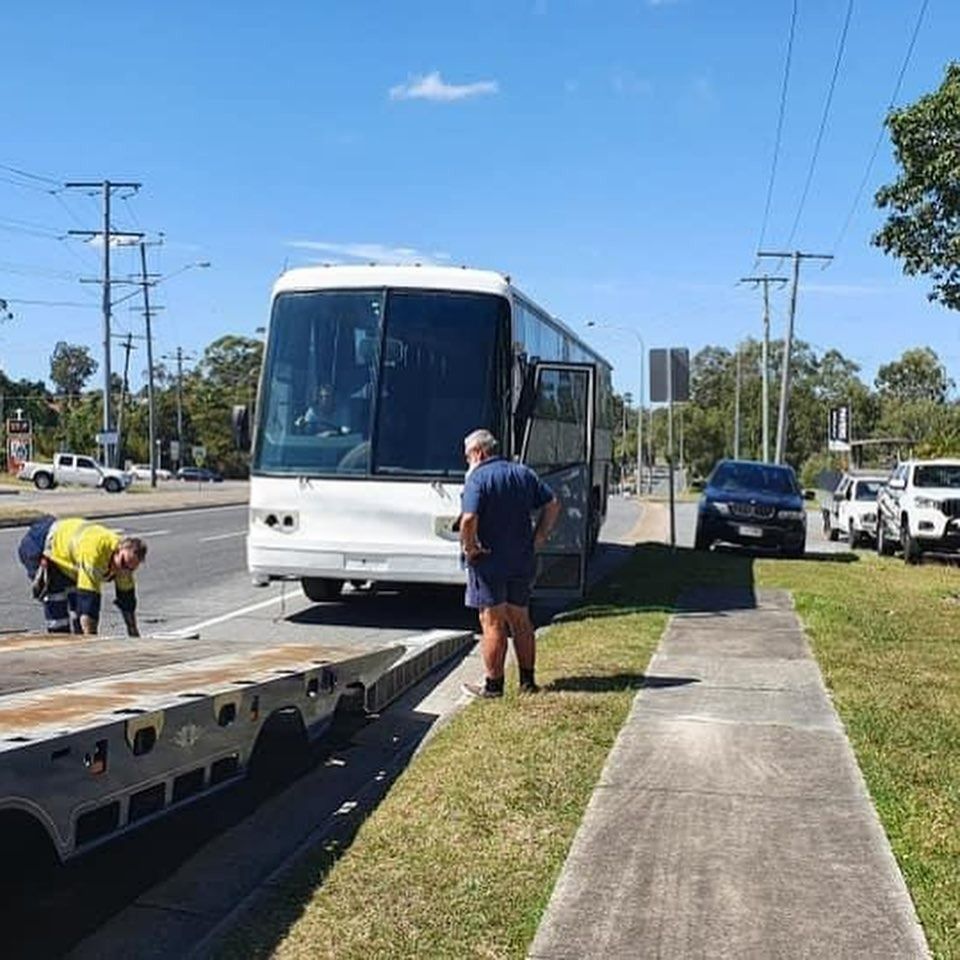 A Tow Truck With a Red Car on the Back — Mick’s Towing Service Pty Ltd in Carrara, QLD