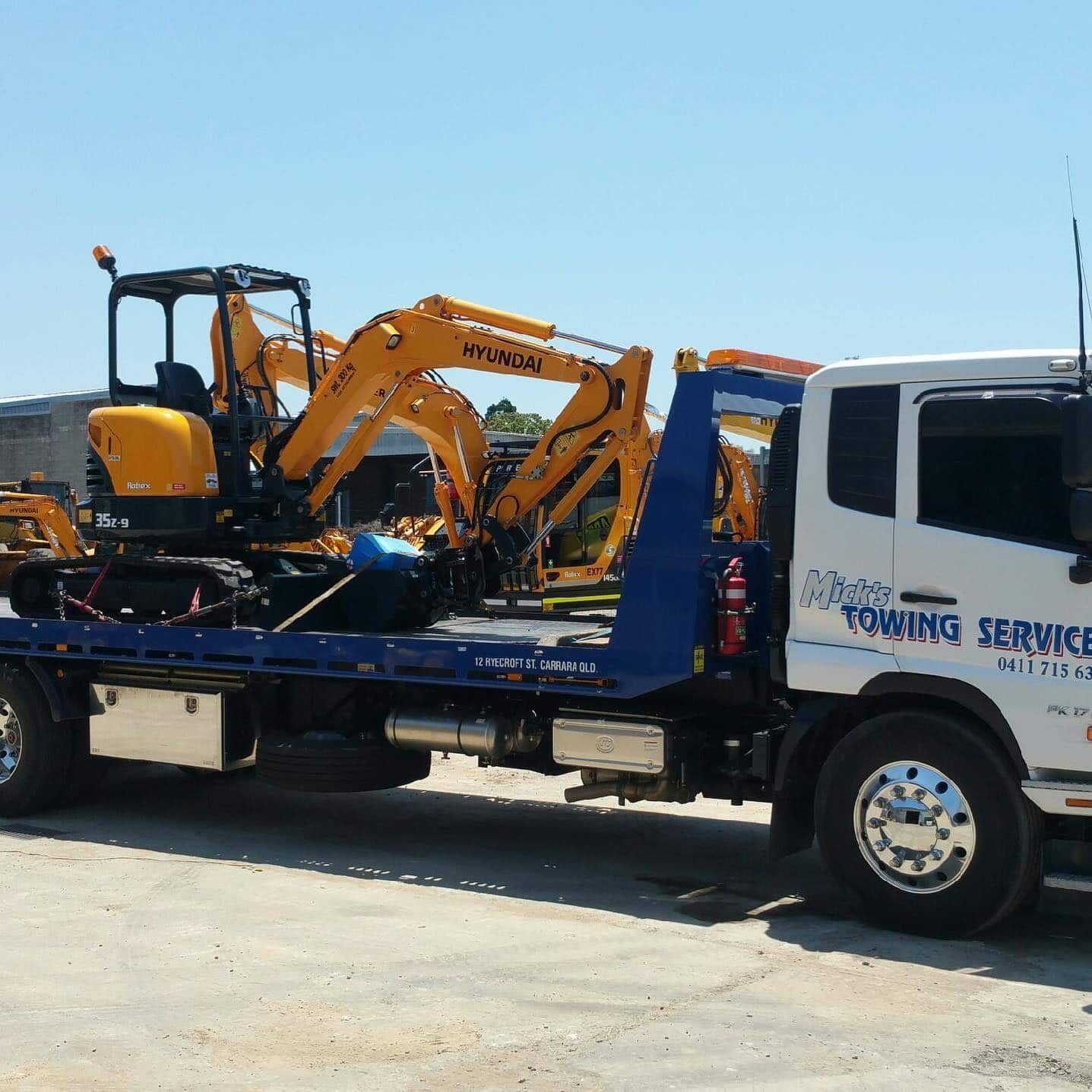 A Hyundai Excavator is on the Back of a Towing Service Truck — Mick's Towing Service Pty Ltd in Carrara, QLD