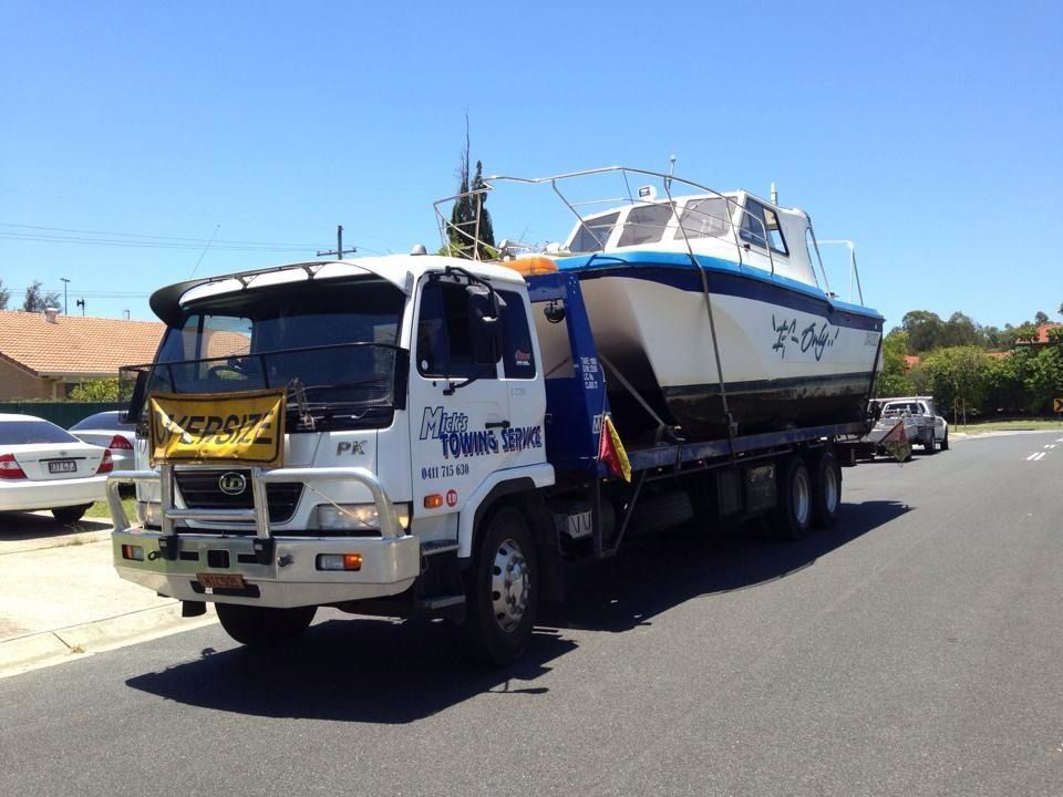 A Tow Truck With a Red Car on the Back — Mick's Towing Service in Carrara QLD